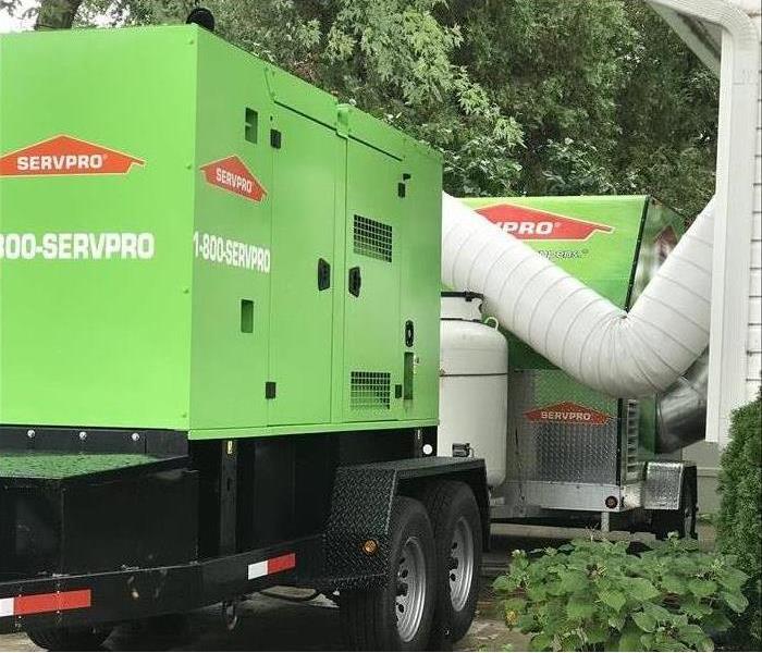 A desiccant and generator outside a home restoring it after flooding 